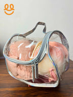 Clear heart-shaped toiletry bag with pink towel, hairbrush, and peach bath pouf inside