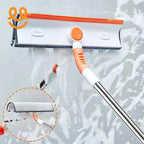 Orange and white window squeegee with microfiber cleaning pad on a soapy glass surface