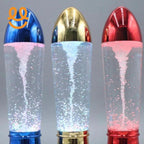 Three decorative lava lamps with blue, gold, and red metallic caps, glowing with bubbles inside clear liquid