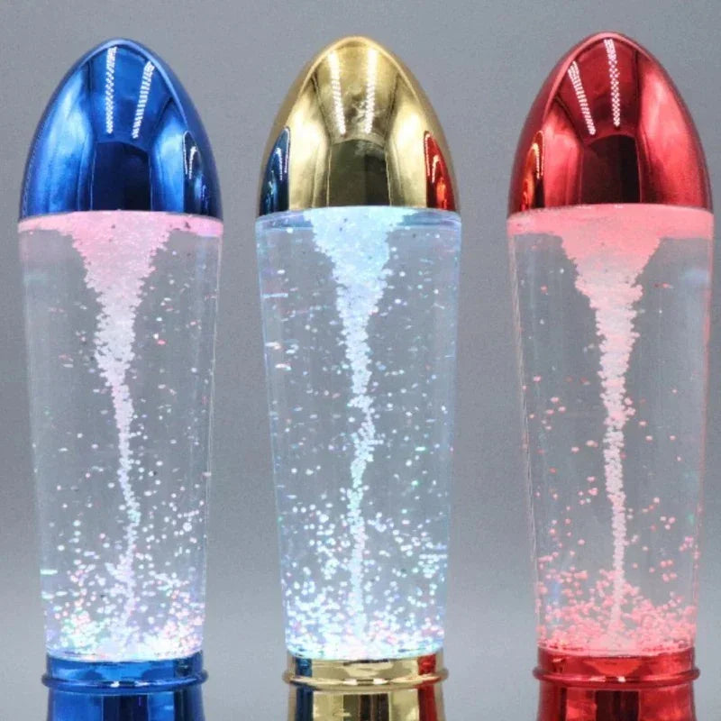 Three decorative lava lamps with blue, gold, and red metallic caps, glowing with bubbles inside clear liquid