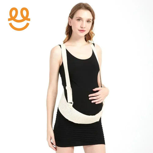 Pregnant woman wearing black dress and beige maternity belly support belt with adjustable straps