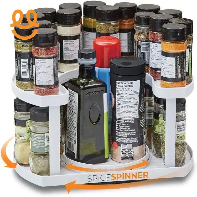 White rotating spice spinner rack holding various spice jars and bottles against white background