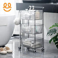 Three-tier clear plastic rolling bathroom storage cart with bottles, towels, and toiletries on gray tiled floor