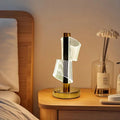 Modern LED bedside lamp with spiral acrylic design on wooden nightstand in cozy bedroom