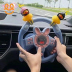 Hands holding a blue toy steering wheel with pink bunny ears and two yellow duck decorations inside a car dashboard