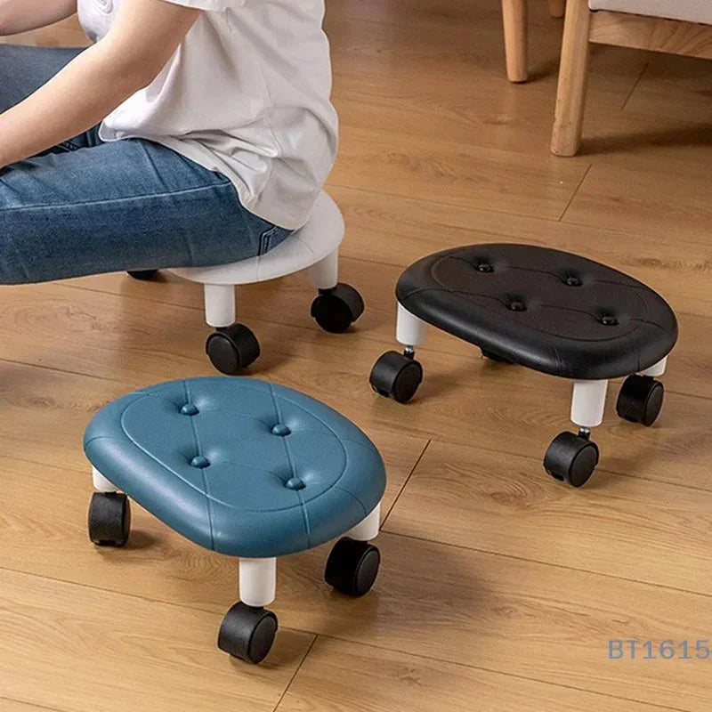 Child sitting on small white rolling stool with black and blue cushioned rolling stools on wooden floor
