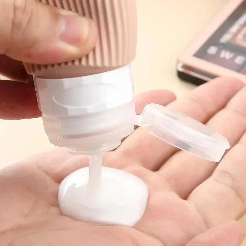 Close-up of hand pouring white lotion from a beige squeeze bottle with flip cap onto palm
