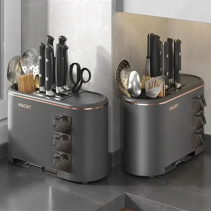 Two black Ascor kitchen knife organizers with knives, scissors, spatulas, and toothpicks on countertop