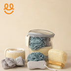 Clear bag with blue bath poufs, exfoliating back scrubbers, headband, and body brush set