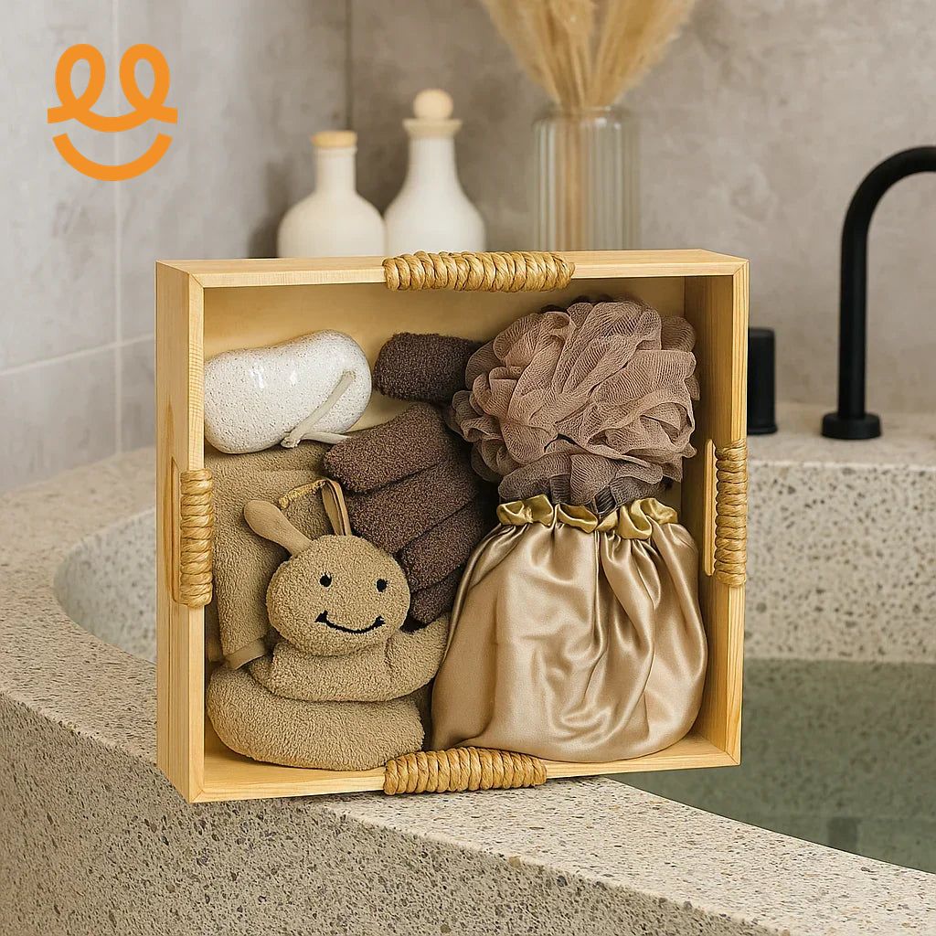 Wooden spa gift box on bathroom countertop with bath sponge, towels, satin pouch, loofah, and pumice stone