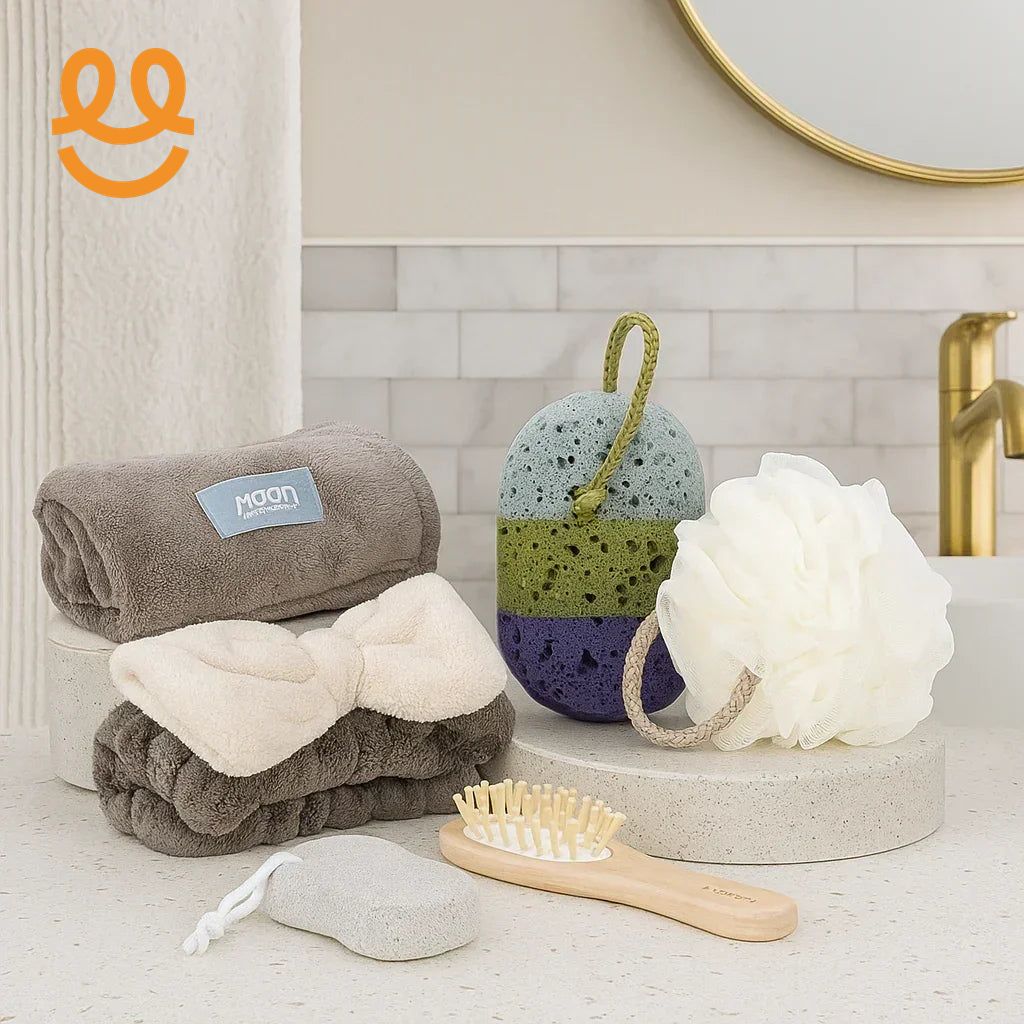 Bathroom essentials including spa towels, exfoliating sponges, wooden hairbrush, and white bath pouf on countertop