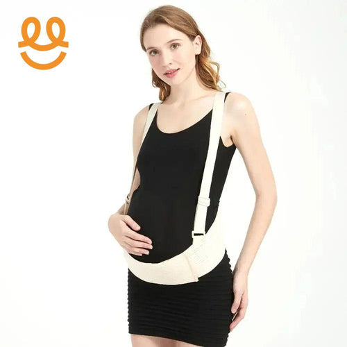 Pregnant woman wearing black dress and beige maternity support belt with straps in studio
