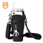 Black insulated water bottle holder with front pocket holding smartphone, keys, and cash, adjustable shoulder strap