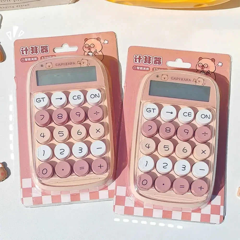 Two pink Capybara-themed calculators with round buttons in packaging on white surface