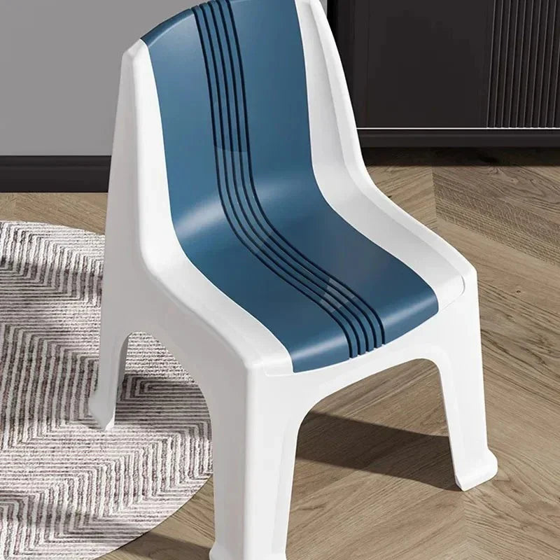 Modern white plastic chair with blue striped seat on wooden floor next to gray patterned rug