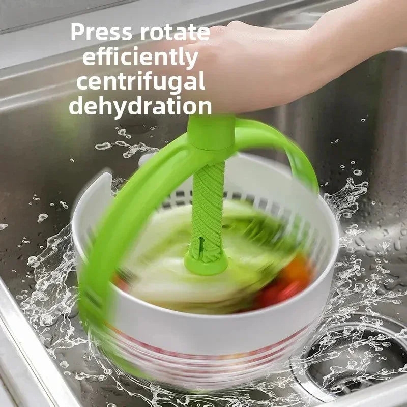 Hand-operated green salad spinner with spinning basket inside white bowl in kitchen sink