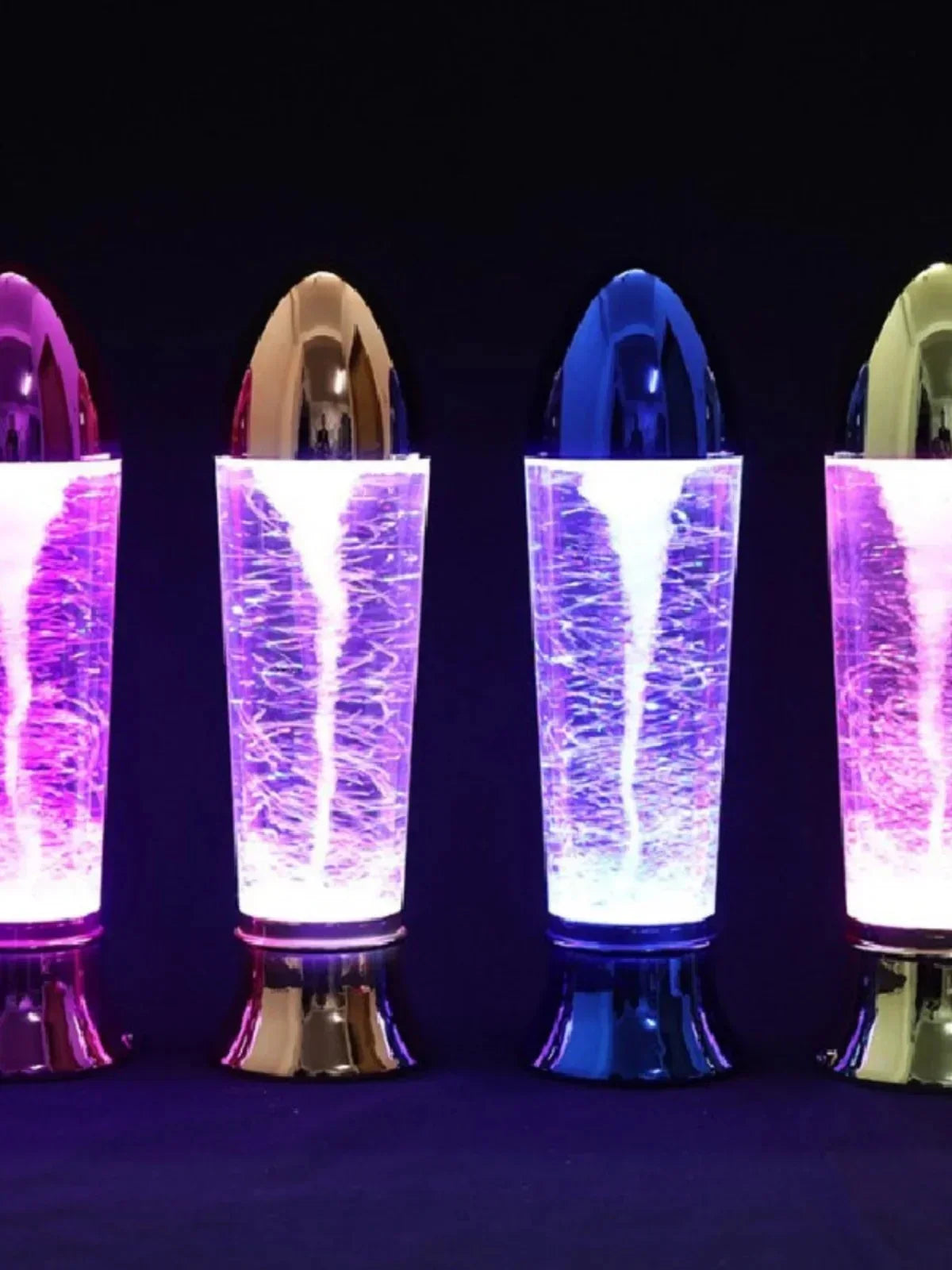 Four colorful LED tornado lamps with swirling light effects against a dark background