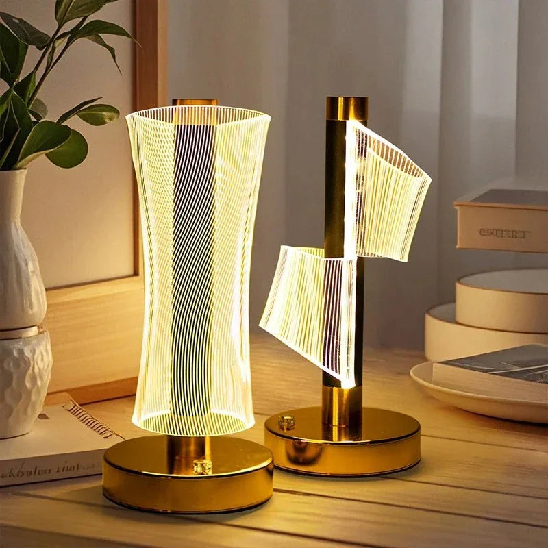 Modern LED decorative table lamps with golden bases and unique spiral and curved light designs on wooden surface