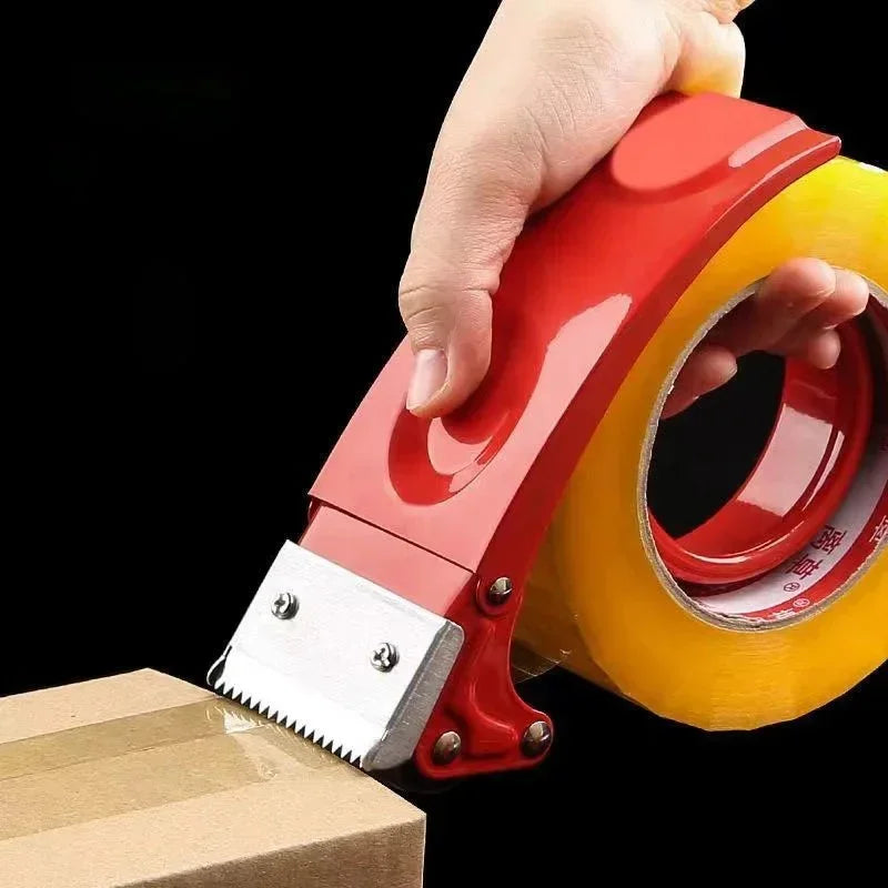 Hand using red tape dispenser to seal cardboard box with clear packing tape against black background
