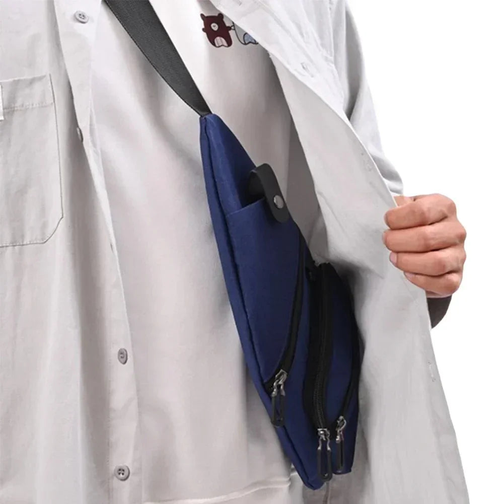 Person wearing gray button-up shirt with navy blue crossbody bag featuring dual zipper compartments