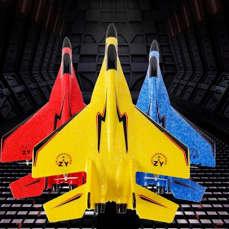 Three colorful foam model jets in yellow, red, and blue with black lightning designs on a dark textured background