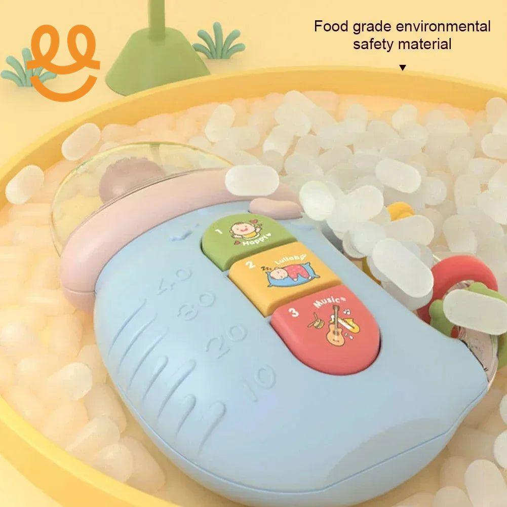 Blue baby toy with music and lullaby buttons in a yellow ball pit with white plastic balls