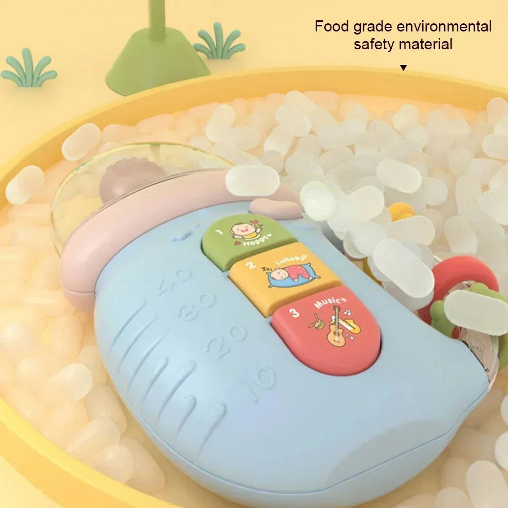 Blue baby toy with music and lullaby buttons in a yellow ball pit with white plastic balls