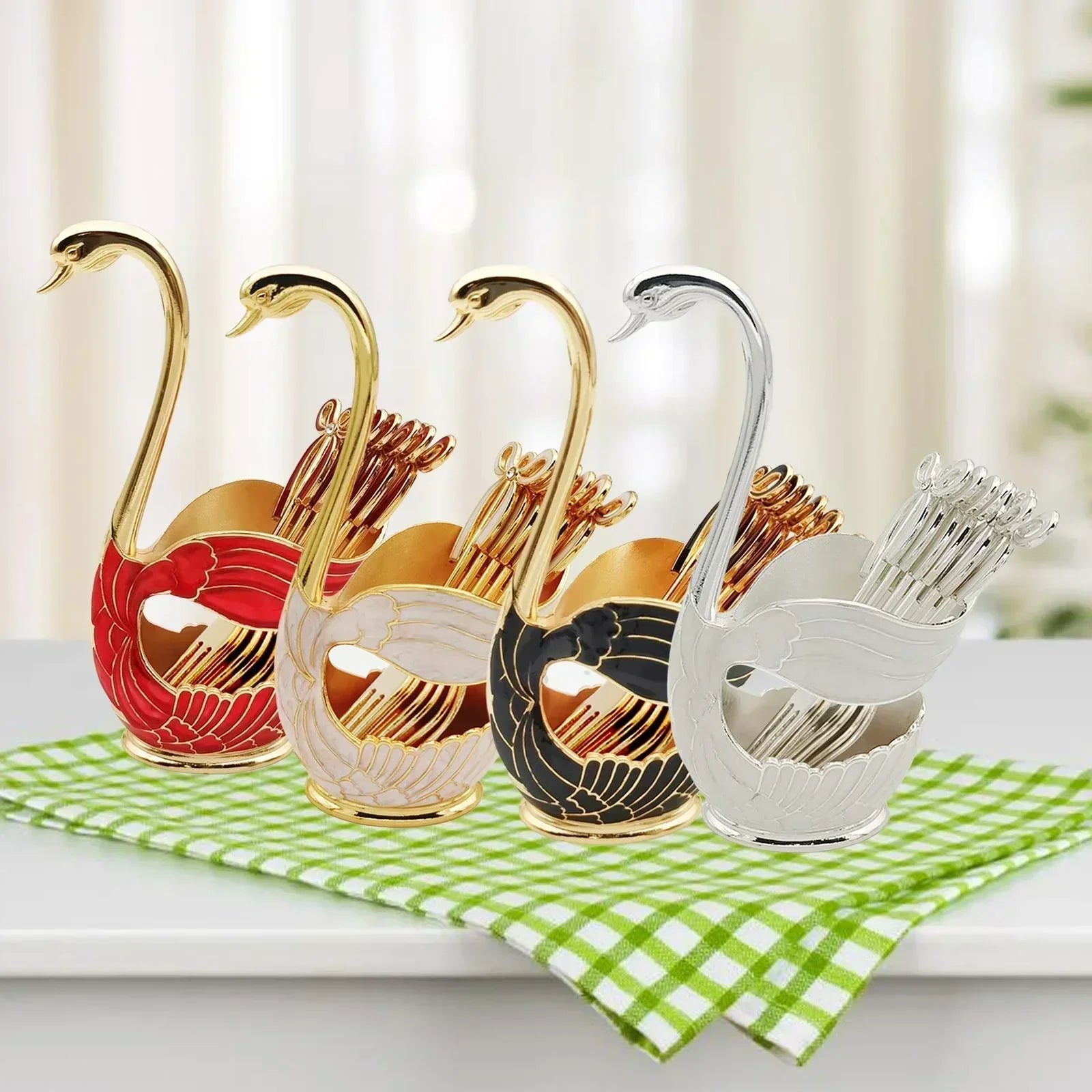 Four swan-shaped decorative holders in red, white, black, and silver with toothpicks on green checkered cloth