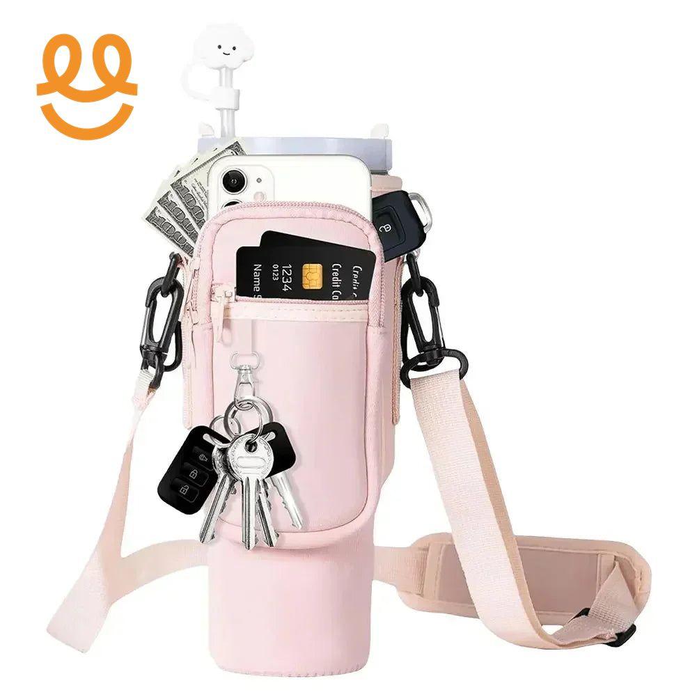 Pink crossbody bag with pockets holding credit card, phone, cash, keys, and car key fobs