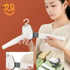 Woman assembling white handheld clothes steamer with detachable handle against orange background