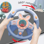 Hands holding a blue and pink kids toy steering wheel with 360° rotation feature and dashboard display
