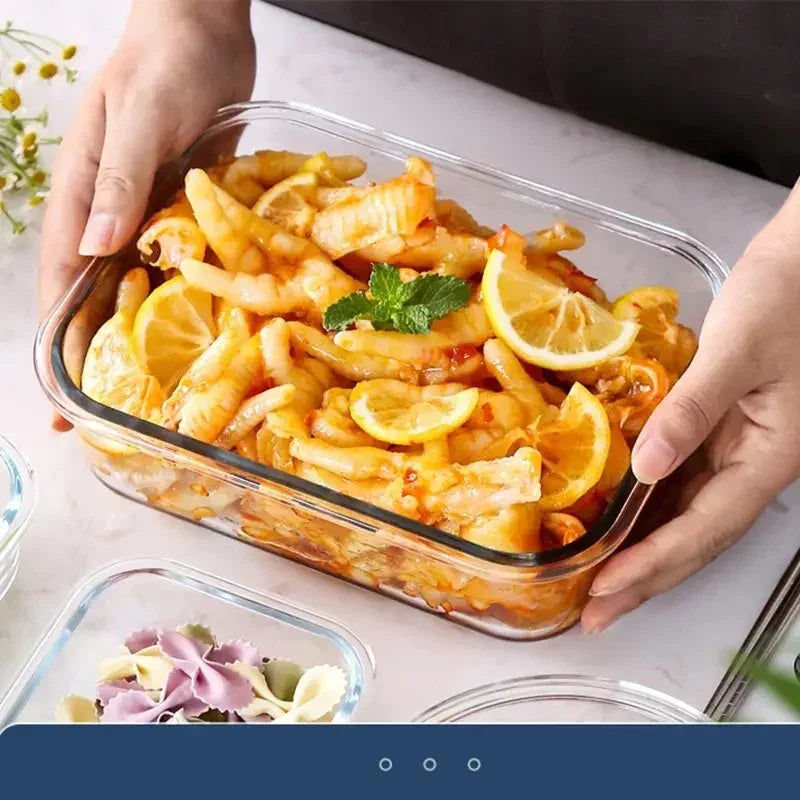 Hands holding glass container with spicy chicken feet garnished with lemon slices and mint