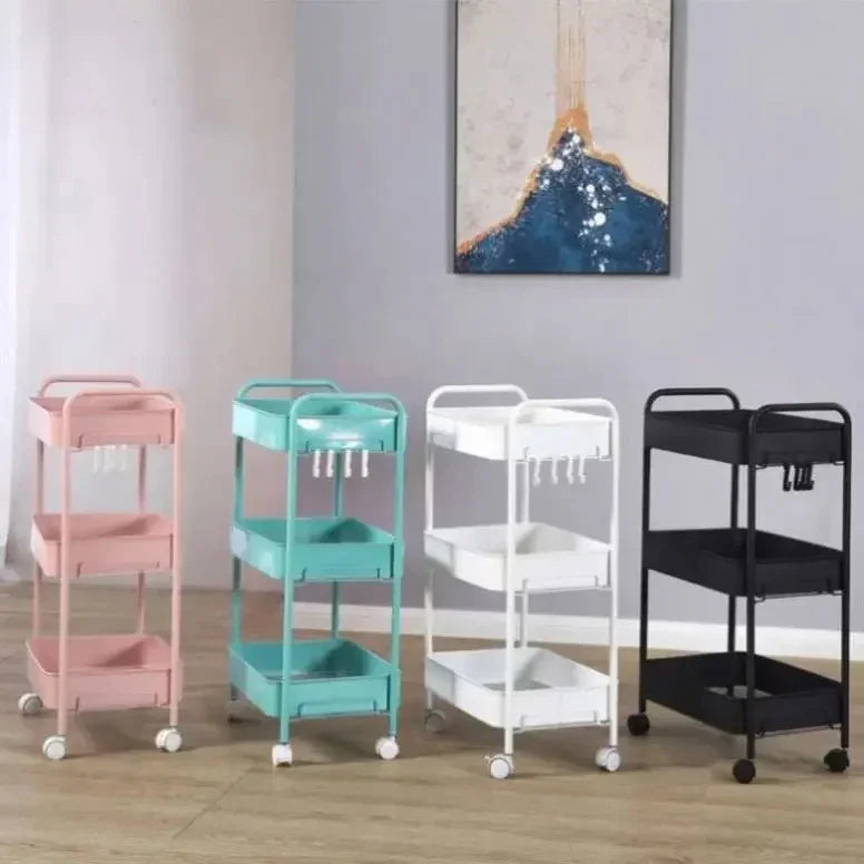 Four three-tier rolling storage carts in pink, teal, white, and black with hooks, set against a living room wall with abstract art