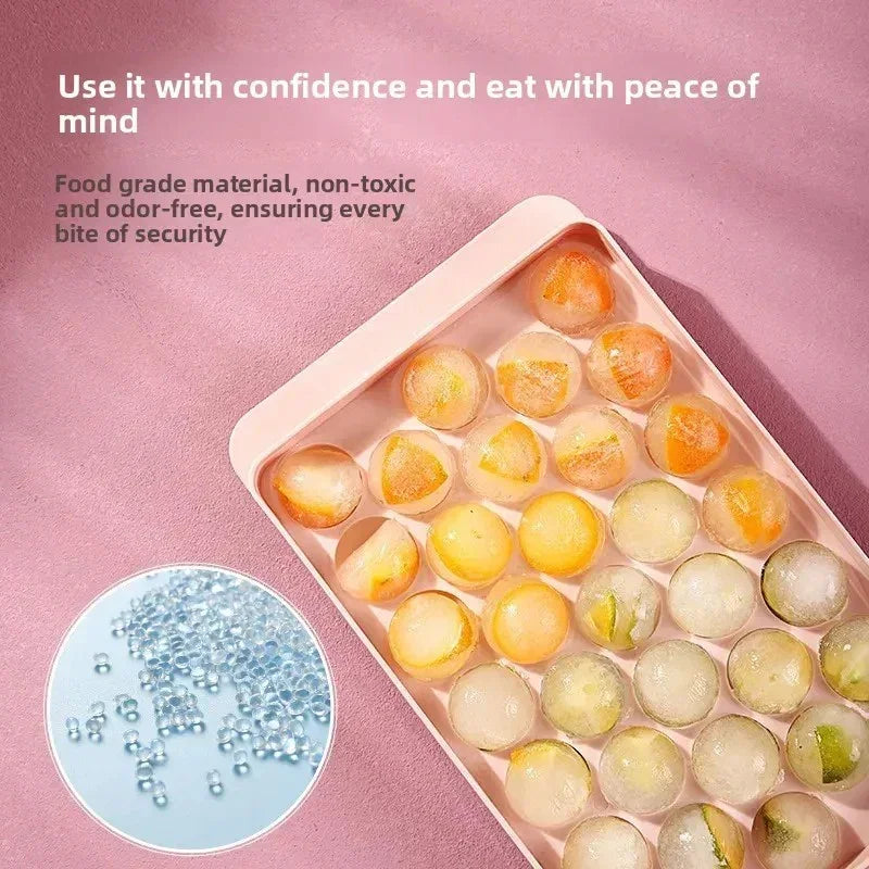 Pink ice cube tray with spherical ice balls containing fruit pieces, promoting food grade, non-toxic, odor-free material