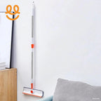 Wall-mounted mop with white and orange handle in a clean modern living room corner