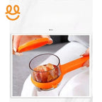 Hand using orange kitchen tool with transparent container to peel garlic cloves