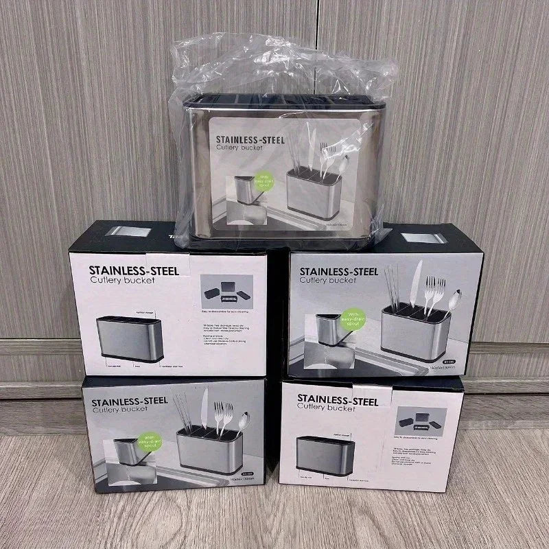 Stack of stainless steel cutlery bucket boxes with images of utensils on a wooden floor