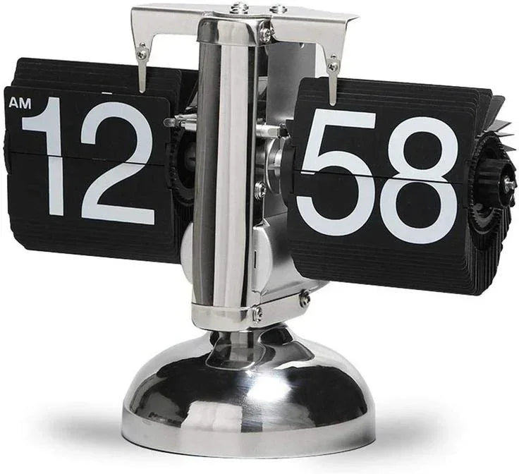 Retro flip clock with black and white numbers on a silver metallic base showing 12:58 AM