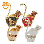 Four swan-shaped toothpick holders in black, red, white, and silver with gold and silver toothpicks