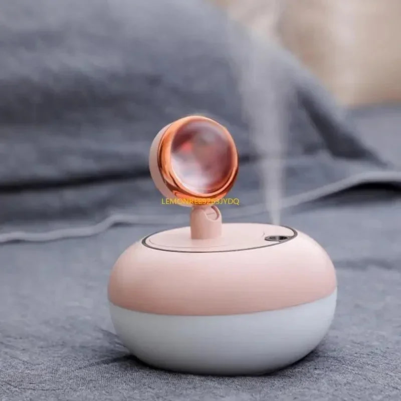 Compact pink and white humidifier emitting mist with a small decorative orb on top on gray fabric