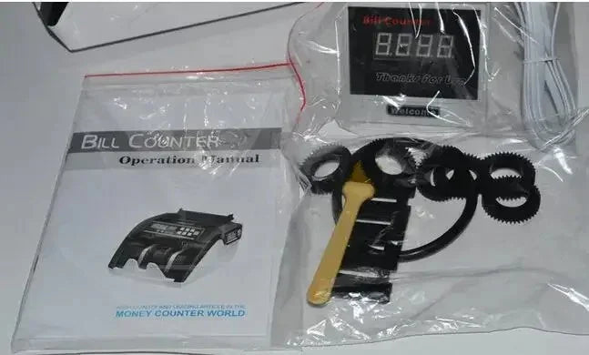 Bill counter operation manual and digital money counter accessories on white surface