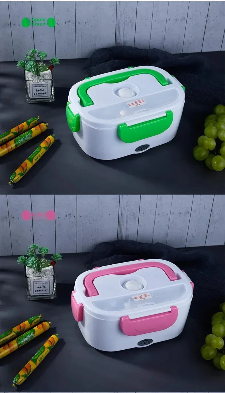 Two electric lunch boxes with handles, one green and one pink, on a dark surface with grapes, sausages, and a small plant