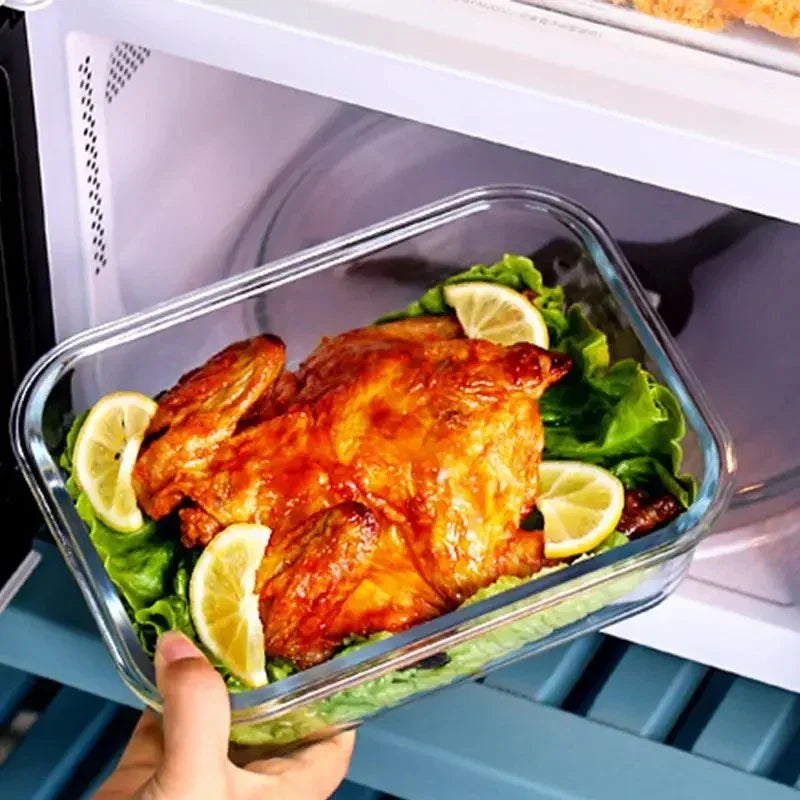 Hand placing a roasted whole chicken garnished with lemon slices and lettuce into a microwave oven