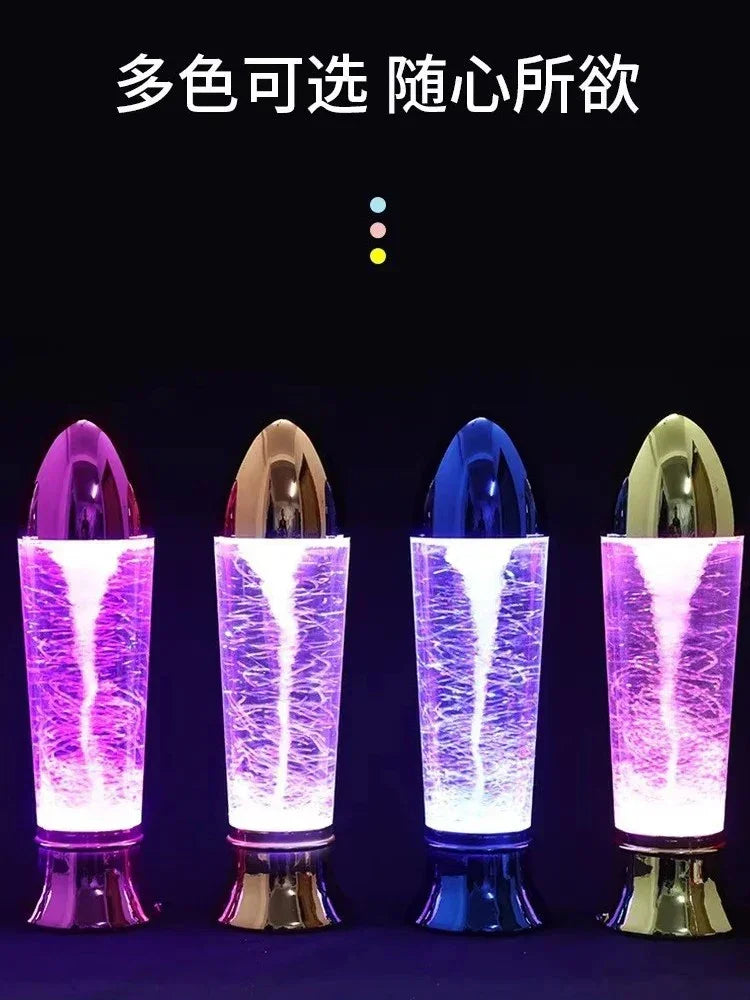 Four colorful decorative water tornado lamps with shiny metallic tops and glowing purple light