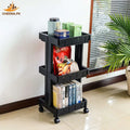Black three-tier rolling storage cart with books, snack packs, and containers in a bright room