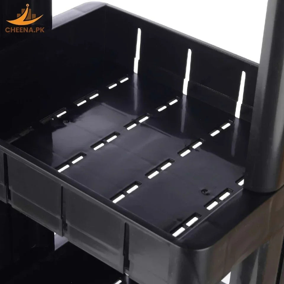 Close-up of black plastic storage shelf with ventilation slots and raised edges