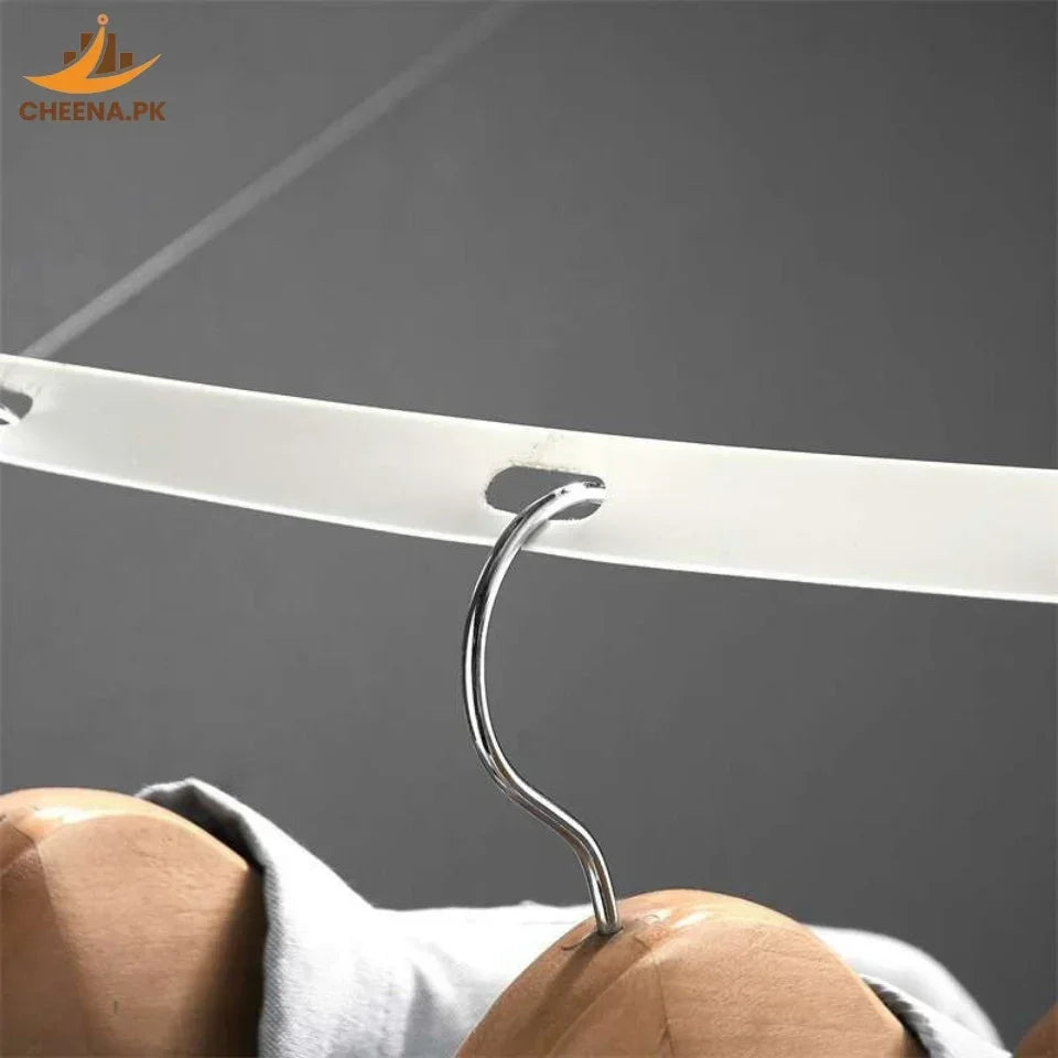 Wooden hanger with a metal hook hanging on a white plastic clothing rack against a gray background