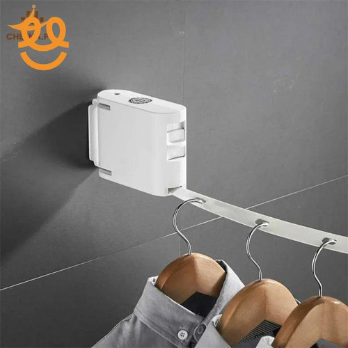 Wall-mounted retractable clothes hanger with multiple wooden hangers holding shirts on grey tiled wall