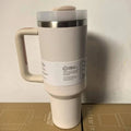 Beige insulated travel tumbler with handle and FlowState 3-position lid on cardboard surface