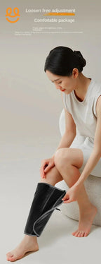 Woman adjusting black leg massager wrap sitting on white chair in minimalist setting